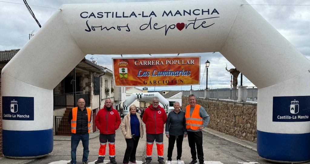 Arco hinchable de la Carrera Popular Las Luminarias en una calle de Garciotum, con varias personas debajo