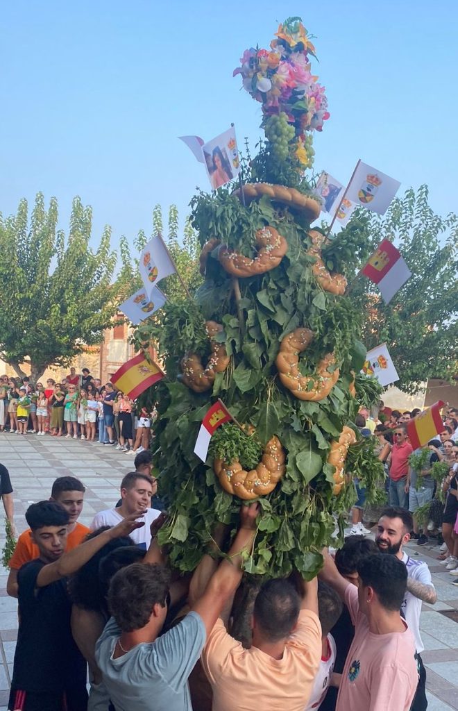 El ramo de la Malena ya montado, con ramas de chopo, roscas de pan y banderitas, sostenido por los mozos en la plaza