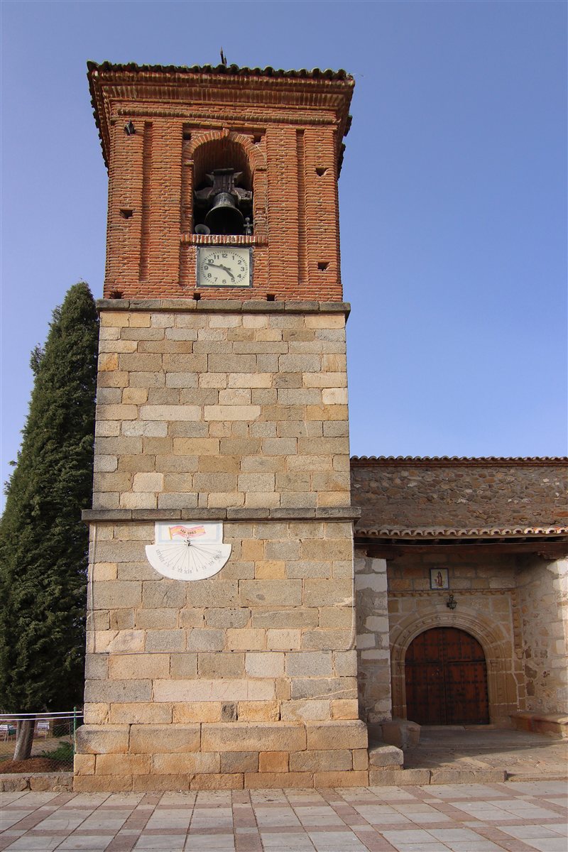 Torre de ladrillo y sillares de la Iglesia de Santa María Magdalena de Garciotum, con el reloj y el cuerpo de campanas